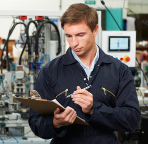 Engineer Writing On Clipboard In Factory