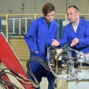 Engineers looking at hydraulic arm mechanism